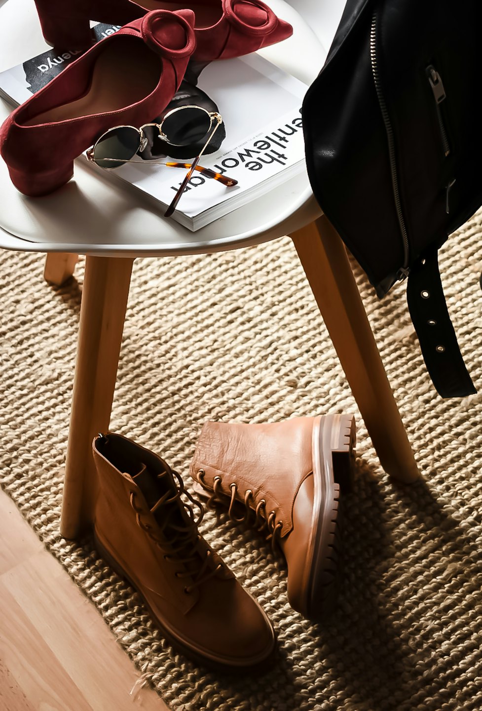 Accessori moda, tra cui tacchi rossi e stivali, su un tavolino.
